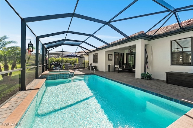 view of swimming pool with glass enclosure, a patio, and a pool with connected hot tub