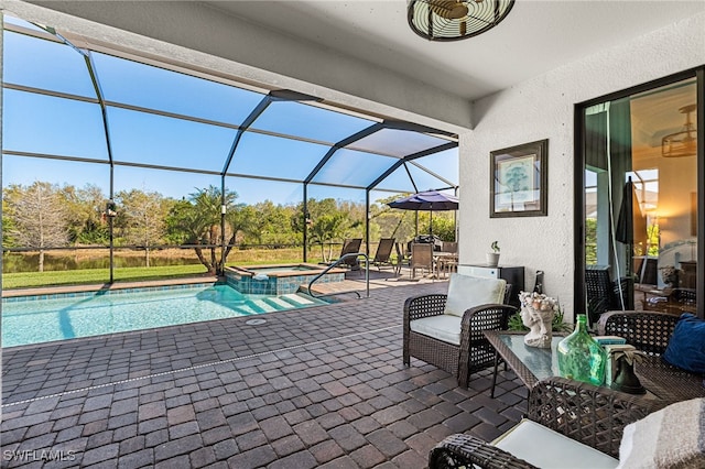 view of swimming pool with glass enclosure, a pool with connected hot tub, and a patio area