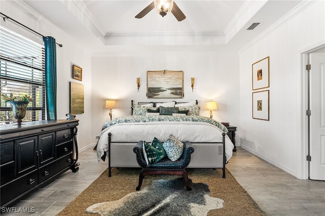 bedroom featuring visible vents, a raised ceiling, baseboards, and crown molding