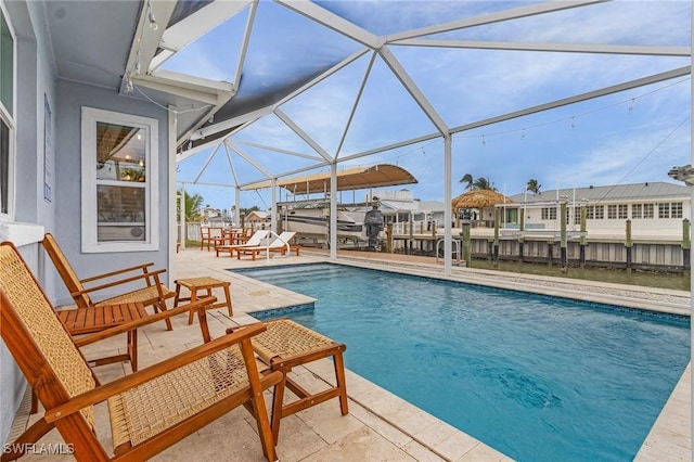 view of swimming pool with a boat dock, glass enclosure, a patio, and a fenced in pool