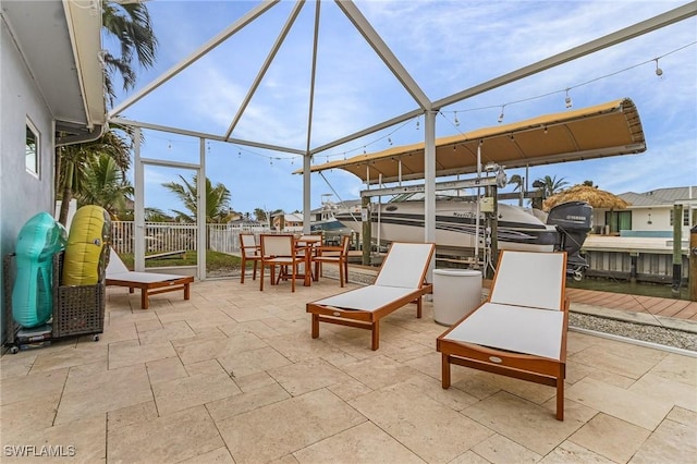 view of patio with glass enclosure, boat lift, and a boat dock