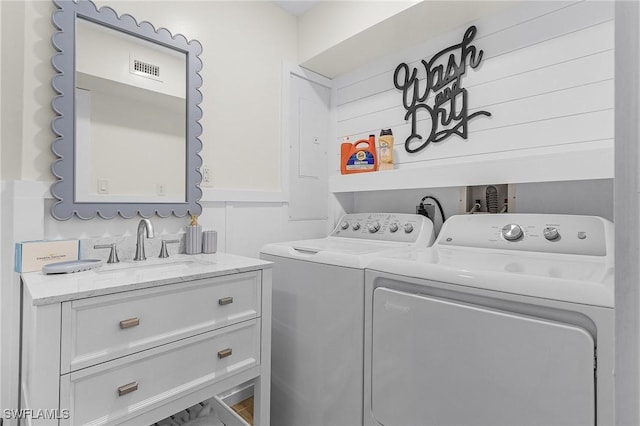 laundry room with visible vents, a sink, cabinet space, wainscoting, and washing machine and clothes dryer