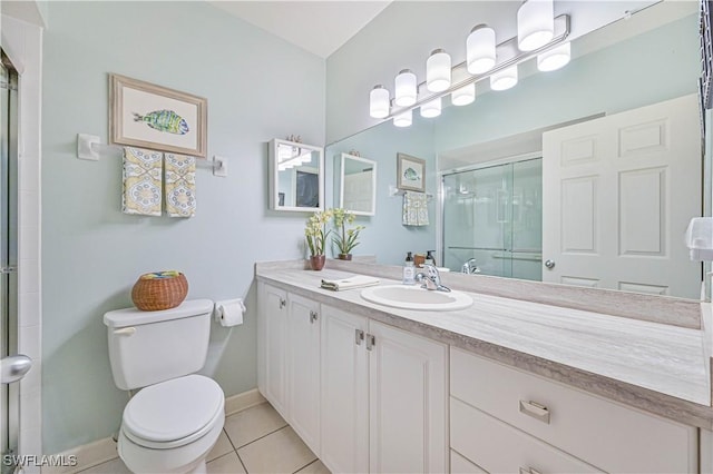 full bath featuring toilet, a stall shower, vanity, baseboards, and tile patterned floors