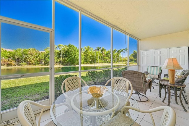 sunroom featuring a water view