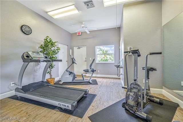 workout area featuring a ceiling fan, wood finished floors, visible vents, and baseboards