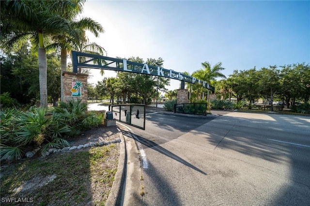 view of road with a gated entry and curbs