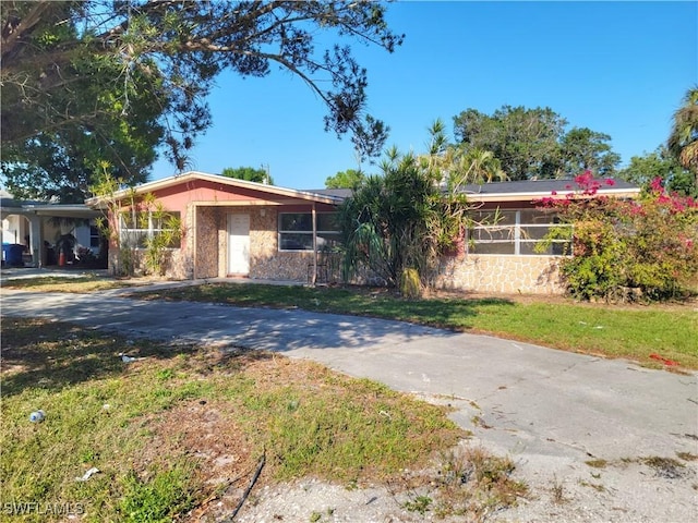 view of front of property with concrete driveway and a front lawn