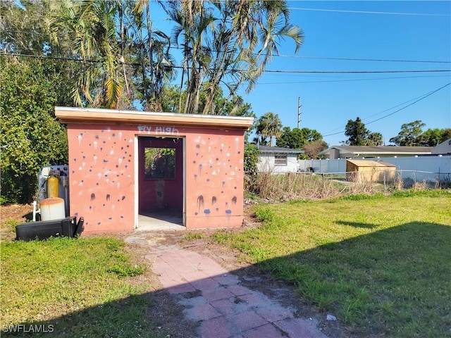 view of outbuilding with fence and an outbuilding