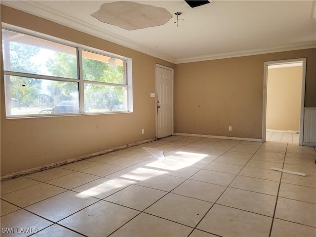 empty room with ornamental molding, light tile patterned flooring, and baseboards