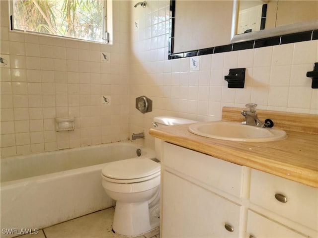 bathroom with toilet, backsplash, tile walls, and vanity