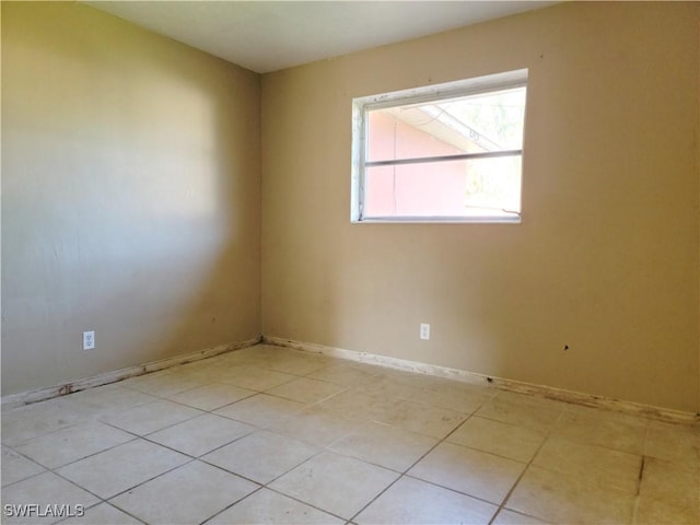 unfurnished room with baseboards and light tile patterned flooring