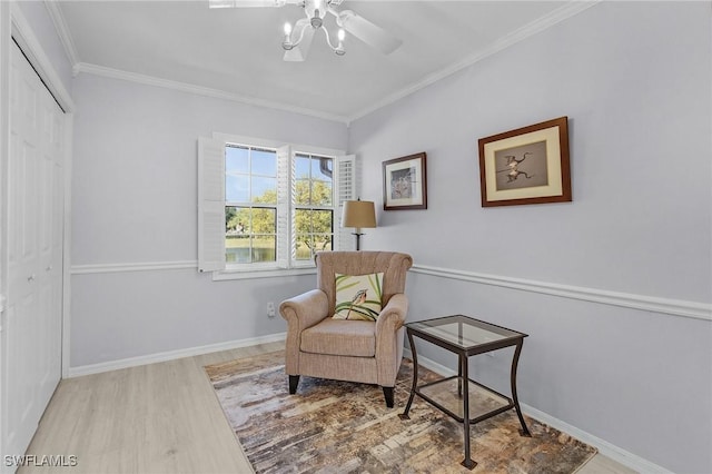 living area with baseboards, wood finished floors, and crown molding