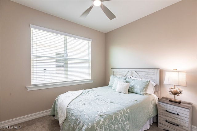 carpeted bedroom featuring multiple windows, a ceiling fan, and baseboards