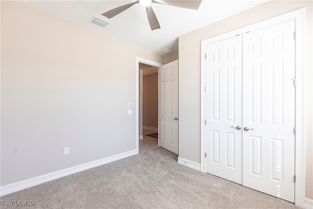 unfurnished bedroom featuring a closet, light colored carpet, visible vents, ceiling fan, and baseboards