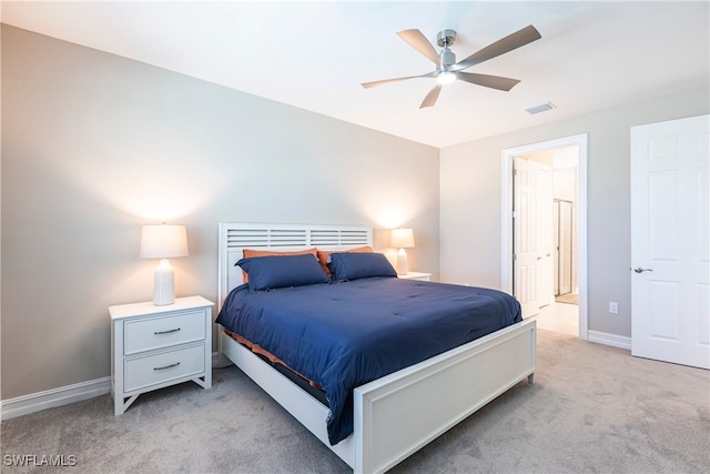 bedroom featuring baseboards, visible vents, light colored carpet, ceiling fan, and ensuite bathroom