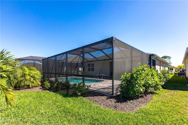 rear view of house featuring glass enclosure, a lawn, a patio, and an outdoor pool