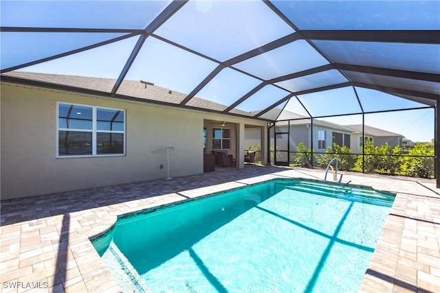 pool with a patio area and glass enclosure