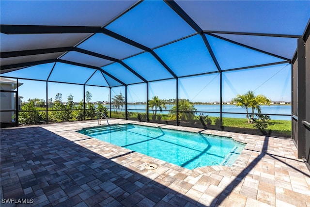 pool with glass enclosure, a water view, and a patio