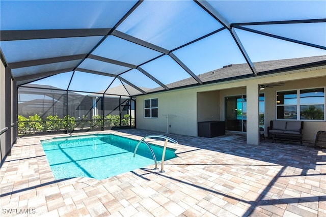 pool with glass enclosure, a ceiling fan, and a patio