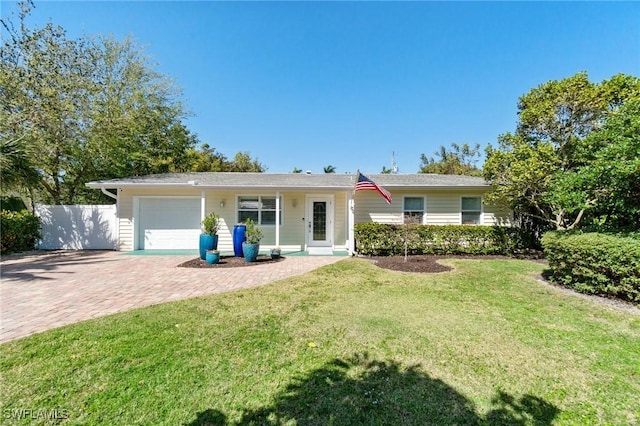 single story home featuring a garage, decorative driveway, a front yard, and fence