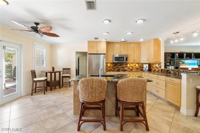 kitchen with light brown cabinets, visible vents, ornamental molding, decorative backsplash, and appliances with stainless steel finishes