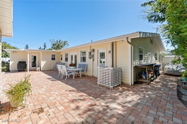rear view of property featuring a patio and fence