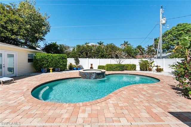 view of swimming pool featuring french doors, a patio, a fenced backyard, and a pool with connected hot tub
