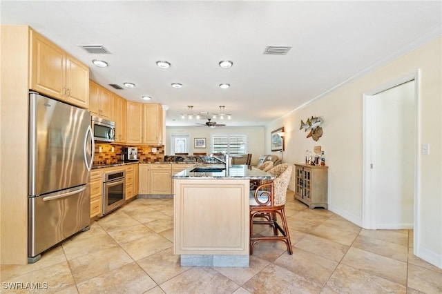kitchen featuring visible vents, appliances with stainless steel finishes, and light brown cabinetry