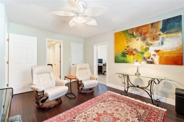 sitting room with baseboards, wood finished floors, and a ceiling fan