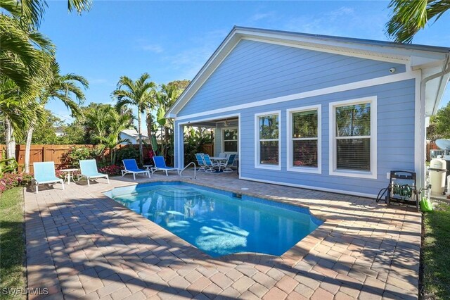 view of swimming pool featuring a patio, fence, and a fenced in pool