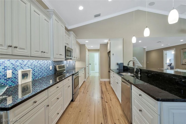 kitchen with stainless steel appliances, a peninsula, a sink, visible vents, and white cabinets