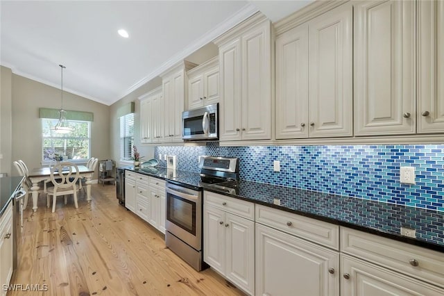 kitchen with light wood finished floors, tasteful backsplash, appliances with stainless steel finishes, vaulted ceiling, and crown molding