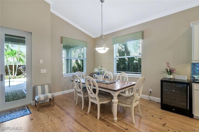 dining area with lofted ceiling, wine cooler, plenty of natural light, and light wood-style flooring