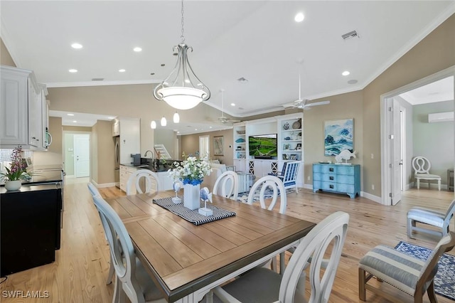 dining area with ornamental molding, light wood finished floors, lofted ceiling, and visible vents