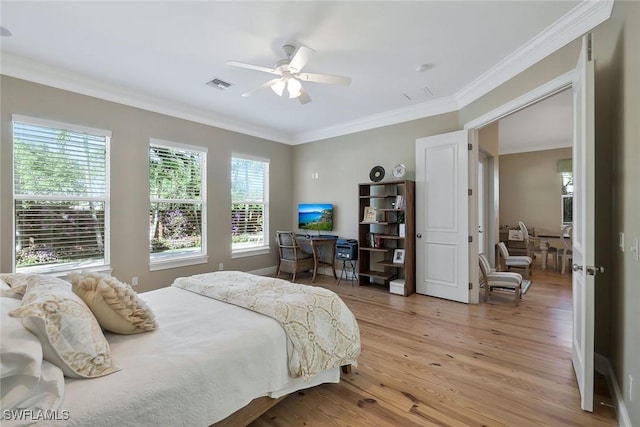 bedroom featuring ceiling fan, light wood finished floors, visible vents, and crown molding