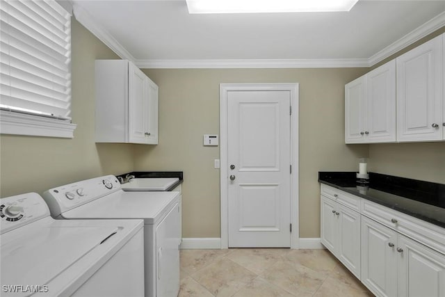 washroom with crown molding, cabinet space, a sink, and separate washer and dryer