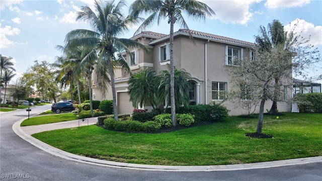 view of side of home with an attached garage, a lawn, a tiled roof, and stucco siding