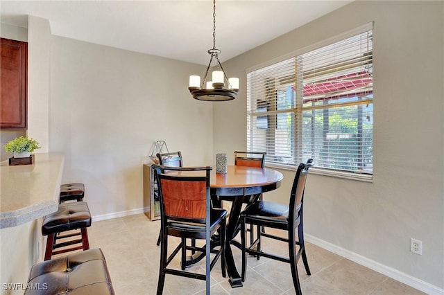 dining space with baseboards, a notable chandelier, and light tile patterned floors