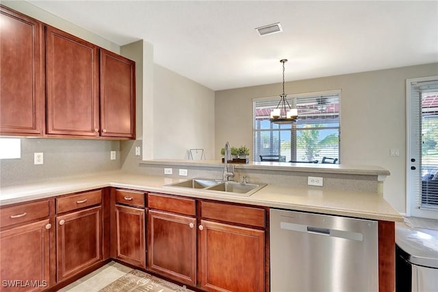 kitchen featuring a peninsula, stainless steel dishwasher, a sink, visible vents, and light countertops