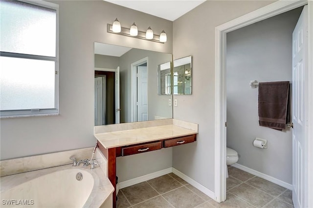 bathroom with a garden tub, vanity, tile patterned flooring, and toilet
