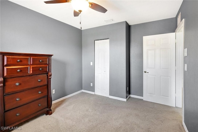 bedroom with visible vents, a ceiling fan, a closet, baseboards, and light colored carpet