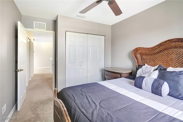 bedroom with baseboards, visible vents, a closet, and light colored carpet
