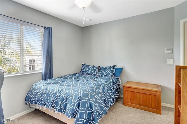 bedroom featuring baseboards, carpet, and multiple windows