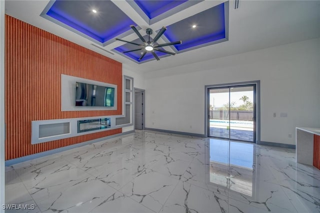 unfurnished living room with ceiling fan, marble finish floor, coffered ceiling, and baseboards