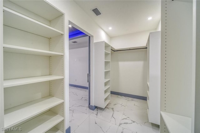 walk in closet with marble finish floor and visible vents