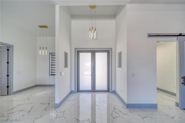 foyer entrance with marble finish floor, french doors, a barn door, and baseboards