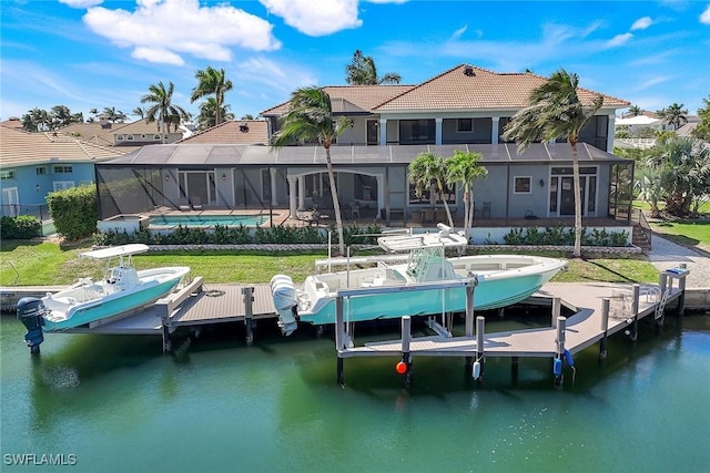 dock area with boat lift, an outdoor pool, and a water view