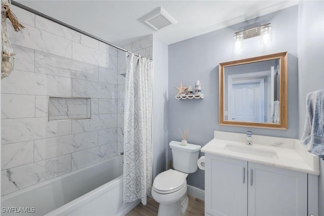 bathroom featuring toilet, wood finished floors, vanity, visible vents, and shower / bath combo