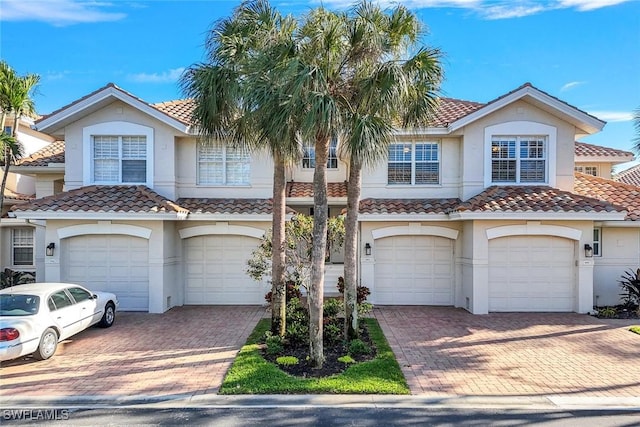 view of front of property with driveway, an attached garage, and stucco siding