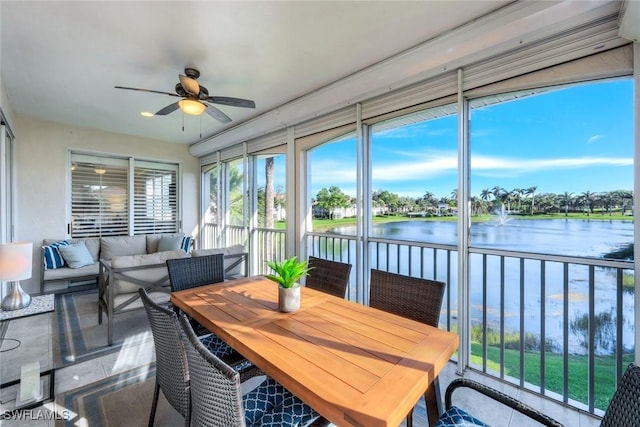 sunroom with a water view and ceiling fan